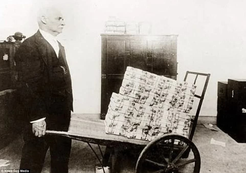 A man carrying a wheelbarrow full of German cash, 1923